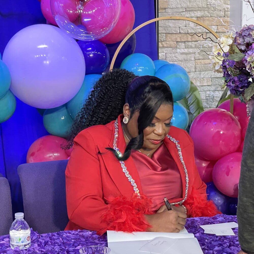 Woman Signs Autograph And Book Signing